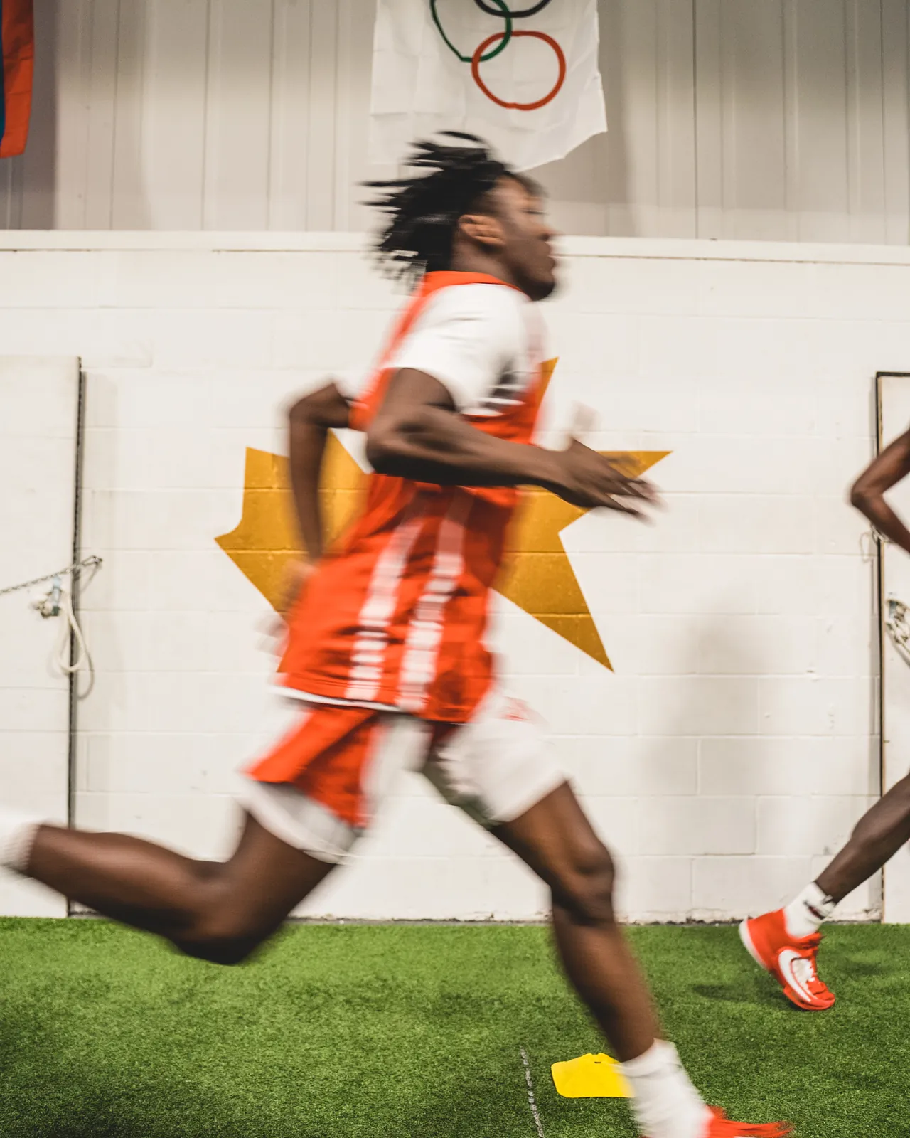 A basketball player sprinting on the CANAM turf