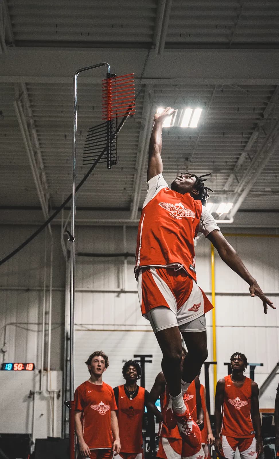 A player reaching on the Vertec with teammates watching at CANAM