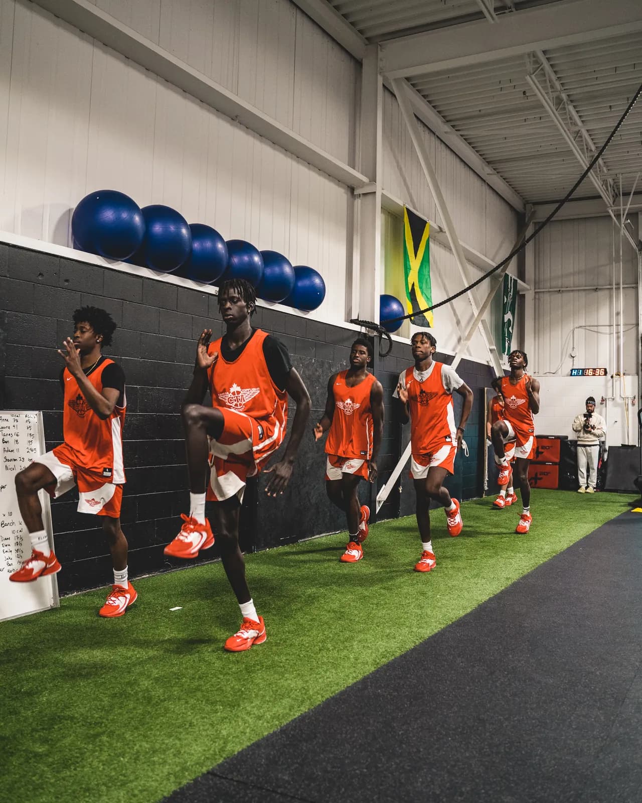 A team doing a high-knee warm-up line on the CANAM turf